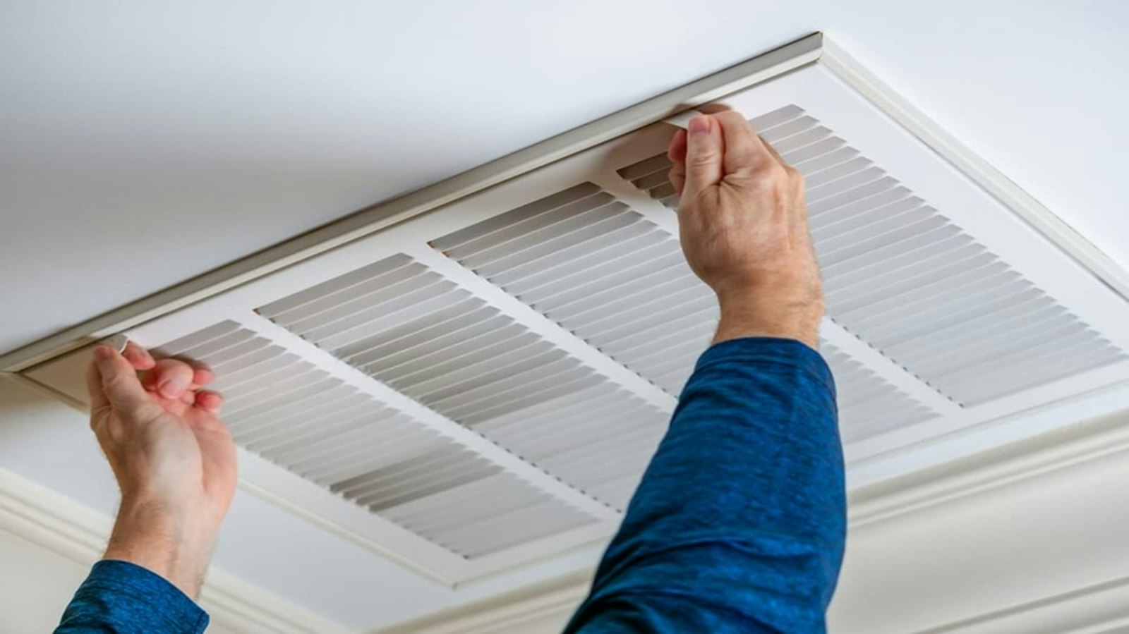 Technician opening a ceiling air return vent